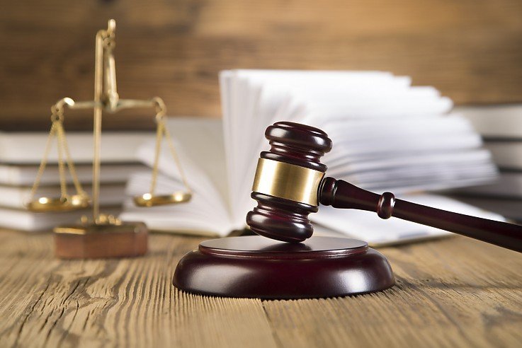 Richterhammer und Justizwaage vor aufgeschlagenem Gesetzbuch als Symbol f�r Immobilienrecht