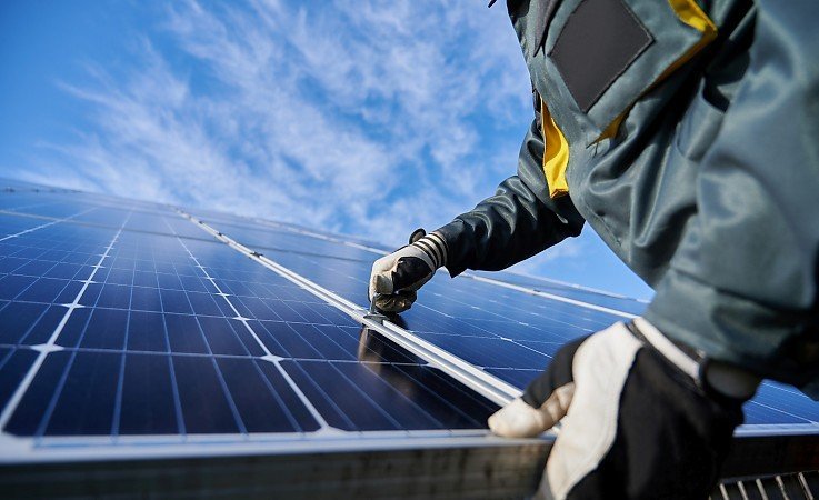 Solaranlagen welche von einem Arbeiter auf dem Dach montiert werden