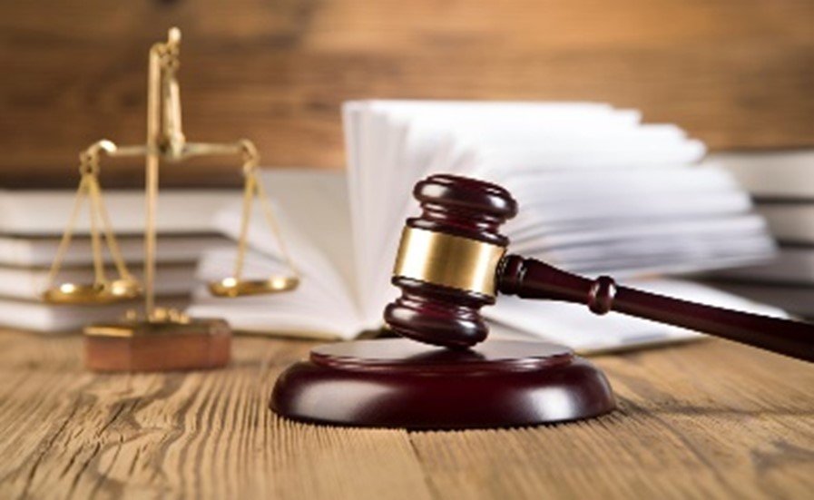 Richterhammer und Justizwaage vor aufgeschlagenem Gesetzbuch als Symbol f�r Immobilienrecht