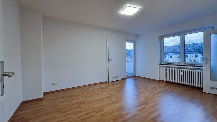 Helles Wohnzimmmer mit Holzboden, Balkonzugang und Fenster mit Ausblick - 2-Zimmer-Wohnung vermitet in Schongau