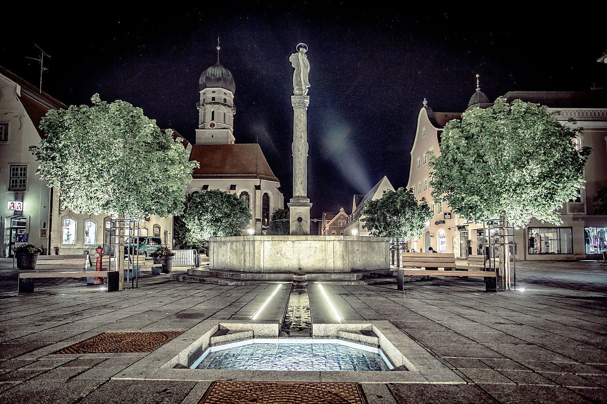Marktplatz Schongau bei Nacht - Mariens�ule und Brunnen mit Blick auf die Stadtpfarrkirche St. Maria Himmelfahrt, beleuchtet unter Sternenhimmel